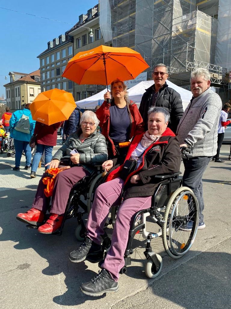 Zwei Rollstuhlfahrerinnen mit Begleitpersonen